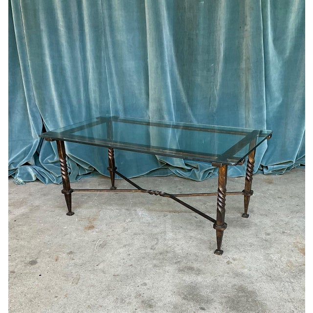 An exceptional French Modernist coffee table from the 1940s, masterfully crafted in wrought iron and clear glass. The...