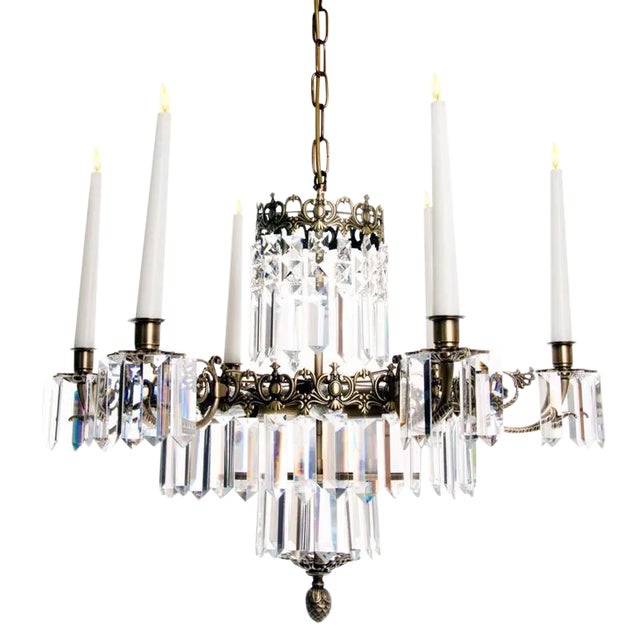A classic Swedish style crystal chandelier with 6 arms for candles and a central bulb inside the brass frame. Ebony...