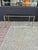 Chic vintage coffee table crafted in brass and steel in Neoclassical forn with figural highlights under a glass top....