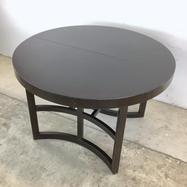 A distinguished example of American mid-century modernist furniture design, this ebonized mahogany round extension dining...