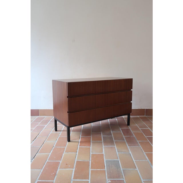 Teak chest of three drawers in the Scandinavian line of the 1960s. The drawer fronts are completely plain, with the pull...