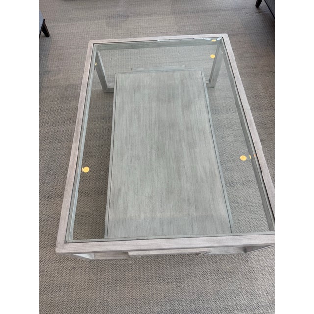 Gorgeous glass top coffee table. The finish is slightly distressed with grey undertones. Brand is not marked (only country...