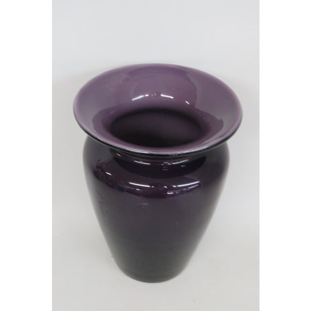 This is a charming small ceramic vase presents a two-toned design with a regal deep purple exterior and lighter purple...