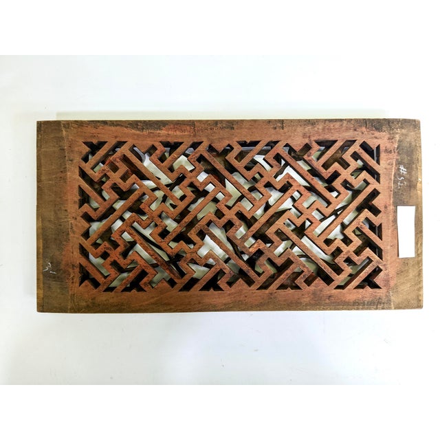 A beautifully carved wooden panel with birds and flowers on a lattice background.