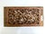 A beautifully carved wooden panel with birds and flowers on a lattice background.
