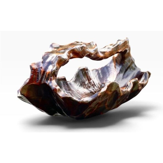 Carved from a single block of rich, highly polished olive wood, this stunning bowl showcases a glossy dark brown finish,...