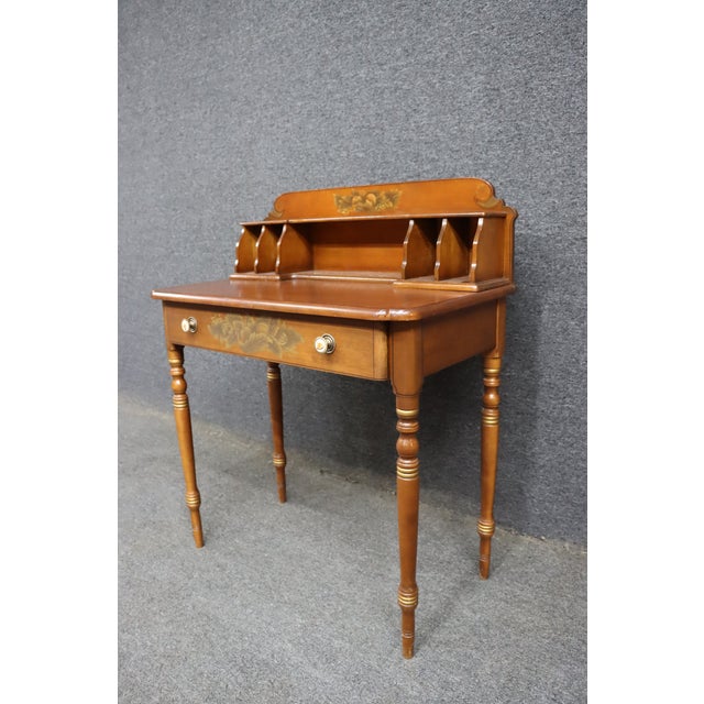 A charming New England writing desk crafted by the Hitchcock Furniture Company of Connecticut. Finished in Cherry, the...