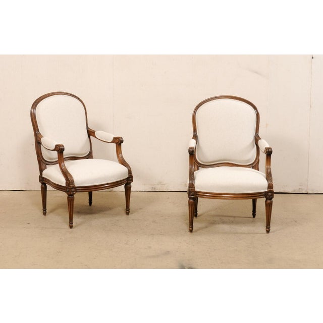 A French pair of timeless and elegant Louis XVI style armchairs from the 19th century. This antique pair of chairs from...