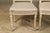 A pair of French Louis XVI style painted side chairs from circa 1920 with rectangular backs, fluted legs, carved rosettes...