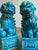 A vibrant and expressive pair of vintage turquoise-glazed foo dogs, featuring richly detailed sculpting and a striking...