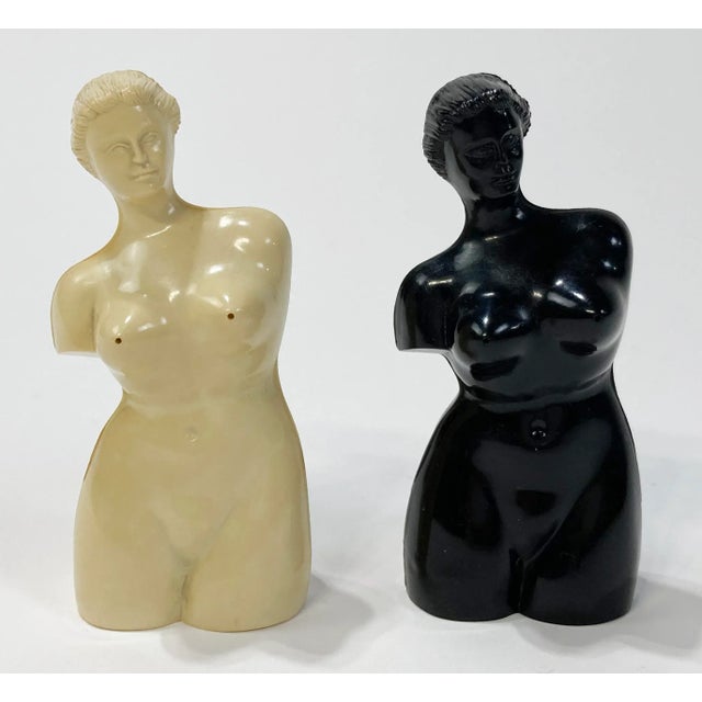 Pair of whimsical resin salt and pepper shakers highlighting the female form. One ivory and one black, salt and pepper...