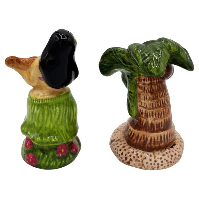 Mid-century brown and green ceramic hula girl and palm tree tabletop salt & pepper shaker set. The set features two...