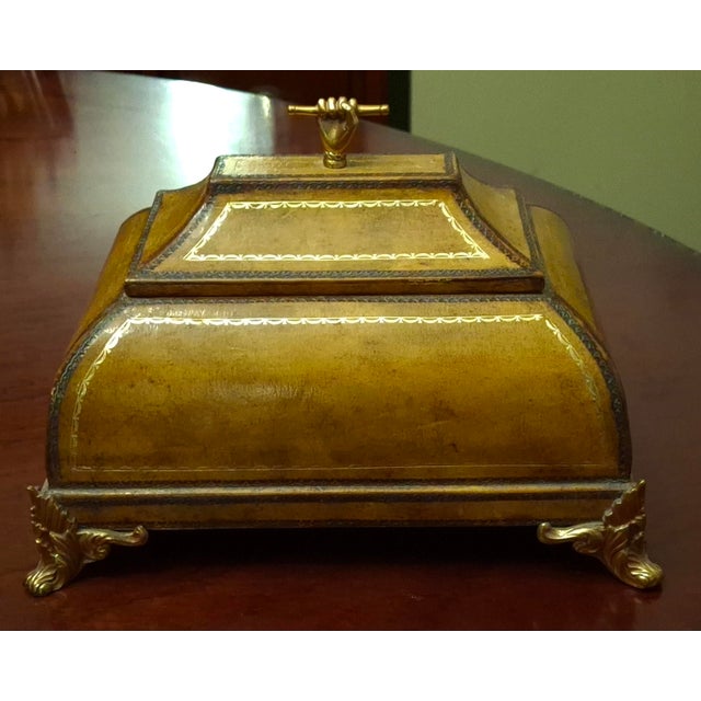 A luxurious Maitland Smith Tooled Leather and Brass Mounts highly Decorative Box produced in the 1980s. It features Tooled...