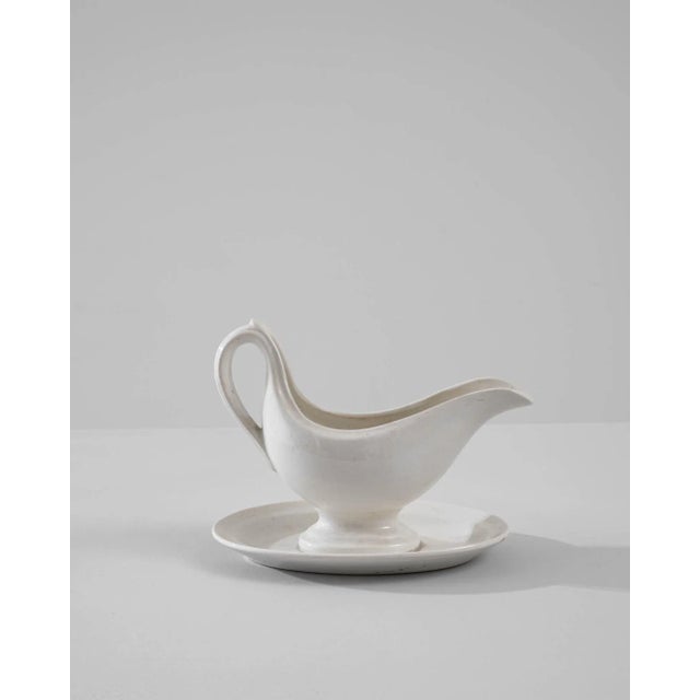 A vintage porcelain sauce boat made in Belgium, circa 1900. White china is finished with a luscious glossy glaze,...