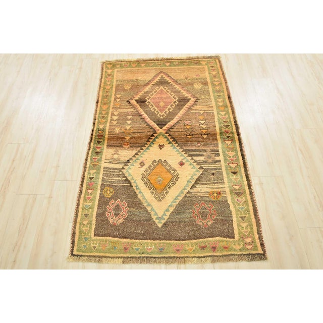 An authentic vintage tribal Gabbeh rug hand-knotted with fine wool and natural dyes. This nomadic oriental rug features...