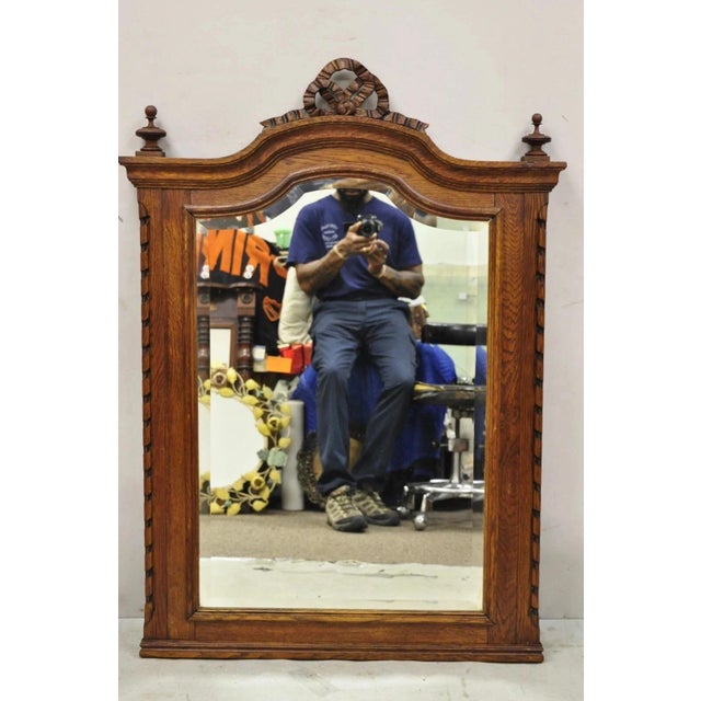 Antique Victorian Carved Oak Wood Ribbon Crest Beveled Glass Wall Mirror. Circa Early 20th Century. Measurements: 48" H x...