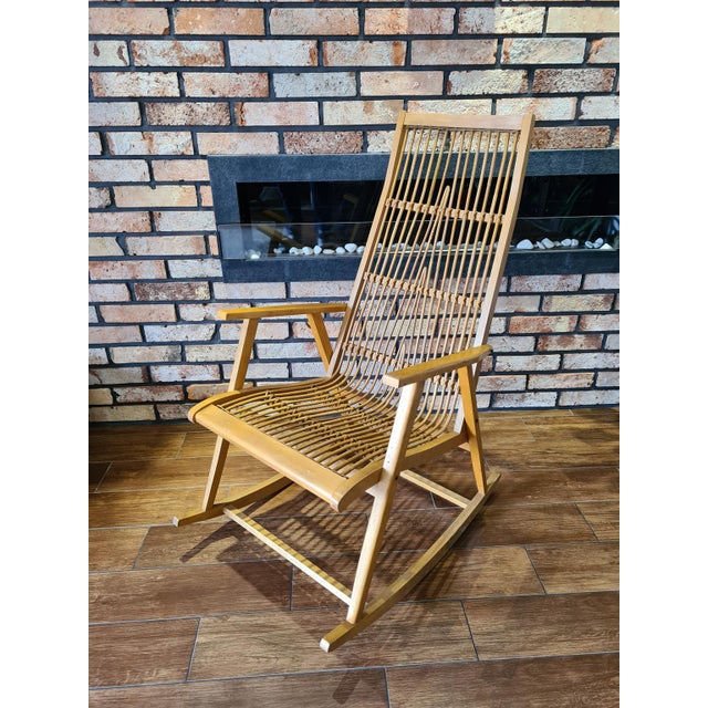 An original mid-century modern rocking chair made of solid wood, featuring a seat and backrest crafted from hand-woven...