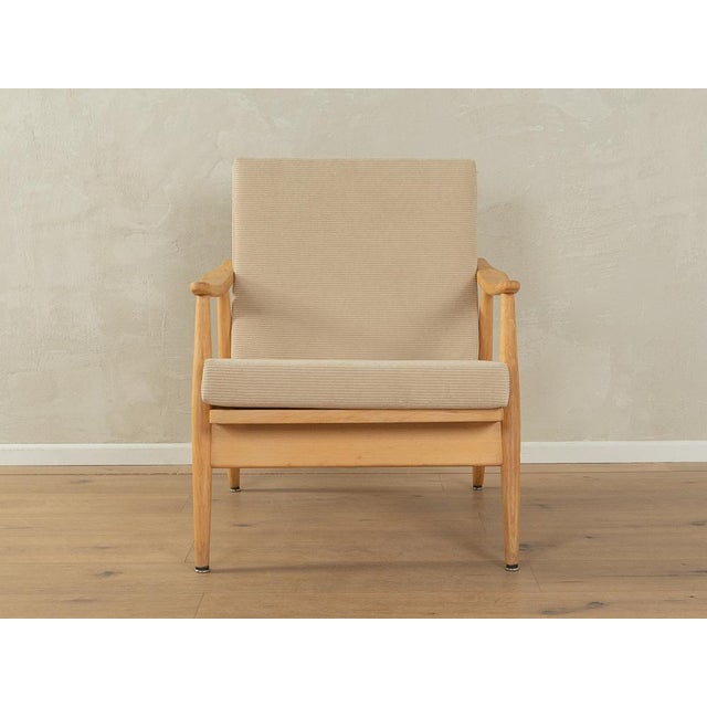 Classic armchair from the 1960s. High-quality solid ash wood frame. The armchair has been reupholstered and covered with a...