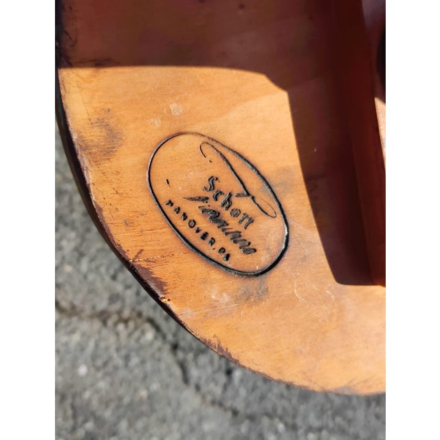 Round table with decorative brass edging on a turned pedestal and three cabriole legs. Marked on the underside "Schott...