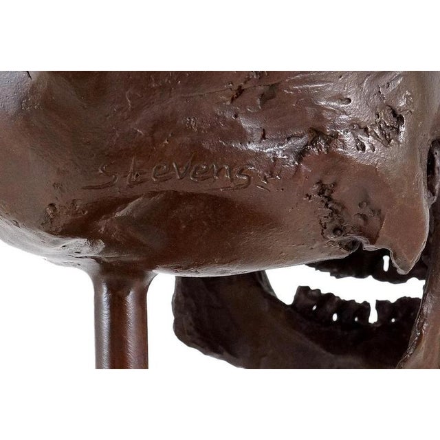 Modern bronze skull sculpture in dark brown patinated bronze, mounted on a marble base. This decorative skull sculpture is...