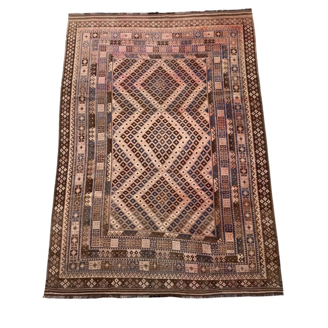 This large handwoven Afghan Maimana Ghalmori kilim has a warm brown base with cream, muted blue, dusty rose, taupe, and...