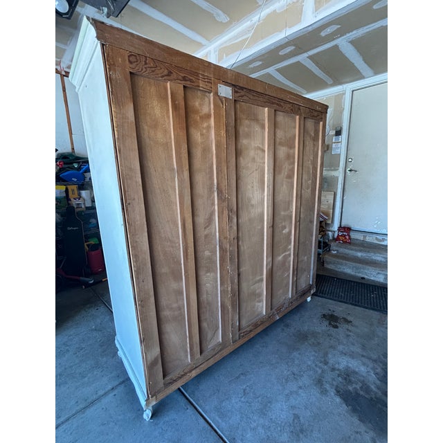 This is a large antique armoire or display cabinet believed to date back to the late 19th or early 20th century. The piece...