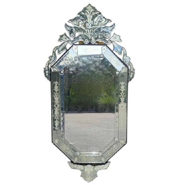 An incredible venetian wall mirror with elegant etched glass. The mirror has beautifully layered cut glass designs with...