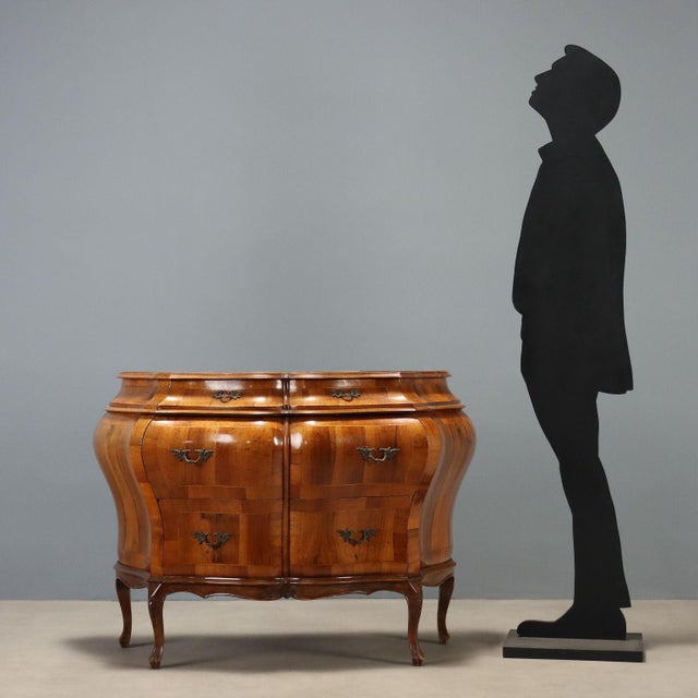 Mid-20th century Chippendale style chest of drawers, featuring a curved and bombe line. Crafted from various woods, it has...