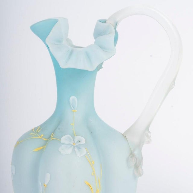 Pair of early 20th-century enameled opaline ewers. H: 27 cm, W: 14 cm, D: 10 cm.