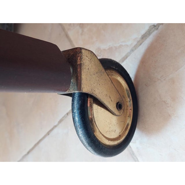 A beautifully crafted two-tiered drinks trolley made of beech wood with a rich mahogany-toned finish, dating from around...