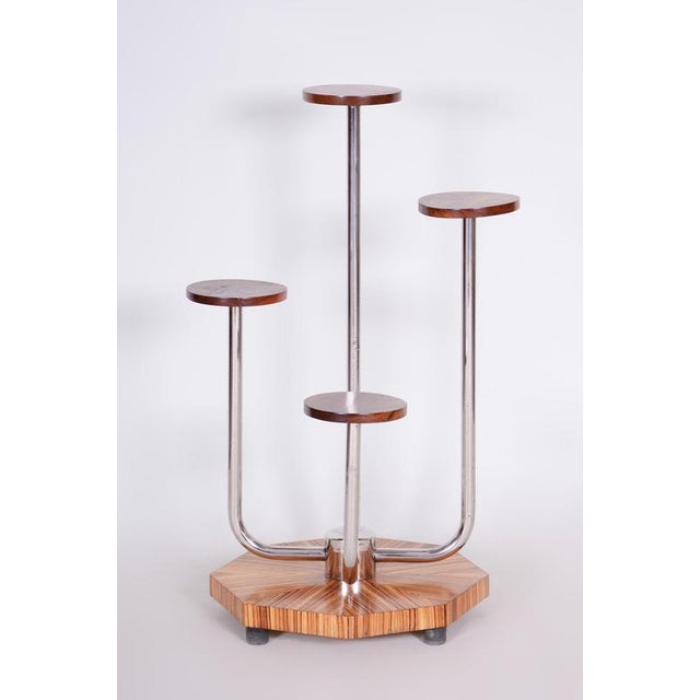 This sophisticated plant stand from the 1930s, originating from Czechoslovakia, carries the signature of the interwar...