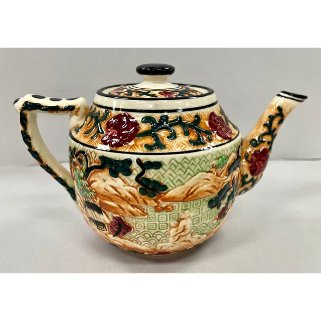 Hand painted majolica teapot. Heavily embossed with asian designs. The teapot measures 9.5 x 6.5 x 6.5 inches tall. No...