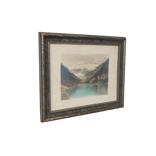 Vintage Lithograph print depicting Lake Louise in Alberta, Canada. It is a scenic mountain view featuring the Victoria...