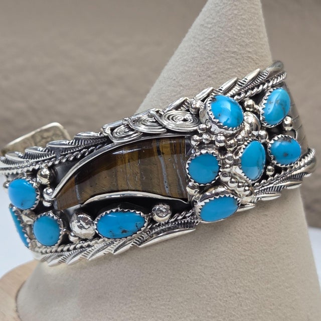 In the heart of Navajo artistry, this cuff tells a tale of nature and craftsmanship. Gleaming sterling silver cradles...