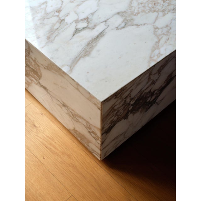 A sculptural Italian marble cube coffee table from the mid-20th century. Crafted with seamless mitered edges, the piece...