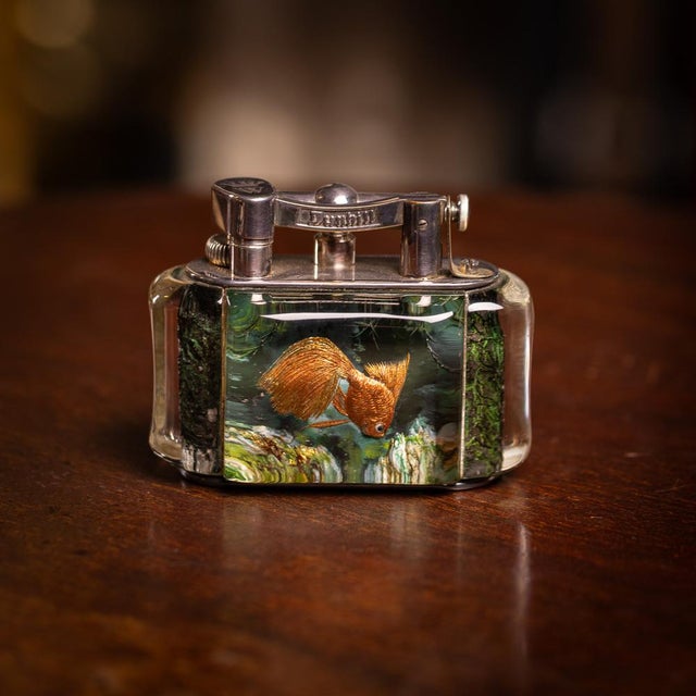 Vintage mid 20th Century Dunhill Aquarium table lighter. Crafted in a curved rectangular shape with silver-plated mounts,...