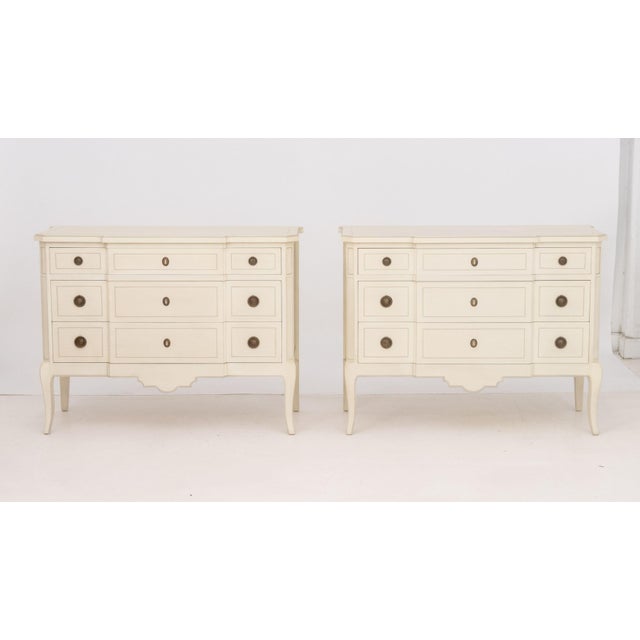 Pair of French Style Cream Painted Commodes, each with three slide drawers and brass hardware. 34" H x 45.5" W x 19" D....