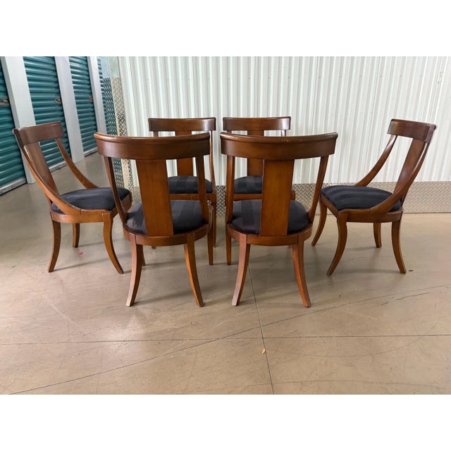 This is a beautiful set of dark wood Klismos style chairs labelled Italy. The design features a tapered and splayed saber...