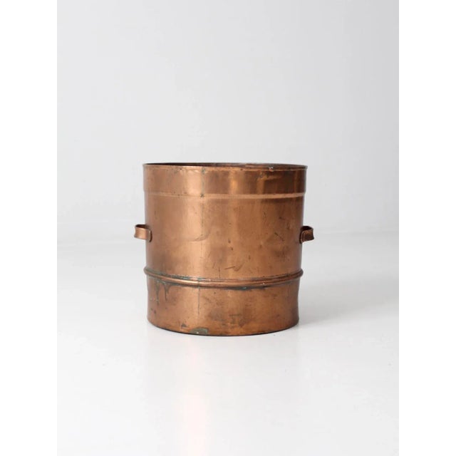 This is an antique copper pot with a unique sieve base. The large, heavy pot features low handles and a reinforced rim...