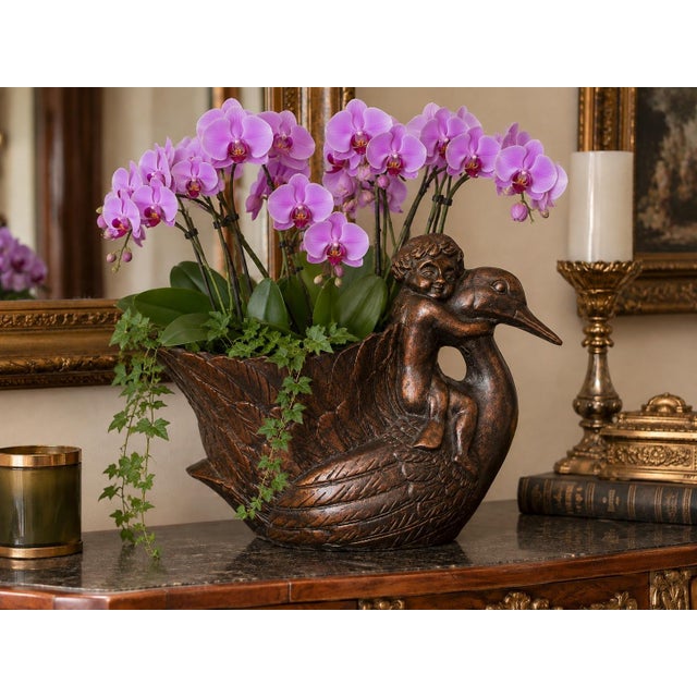 A beautifully sculptural vintage Korean cast metal planter featuring a charming cherub embracing a graceful swan. Finished...