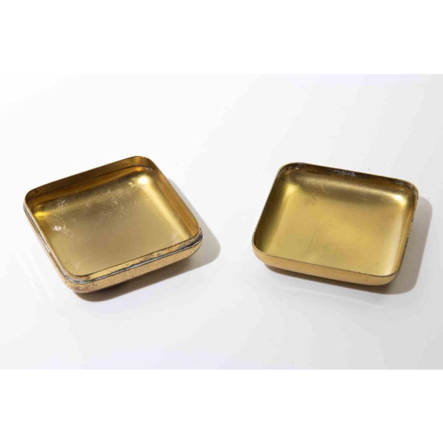 Elegant small rectangular lidded box in polished gold-tone metal, featuring softly rounded corners and a minimalist...