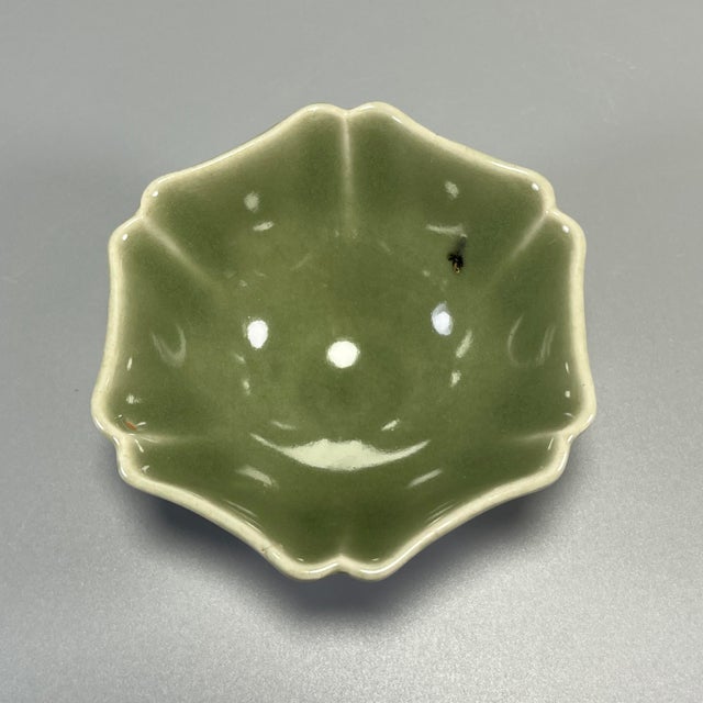 This vintage‑style petal‑lobed celadon cup is covered with glossy olive‑green glaze, presenting elegant flower‑shaped rim....