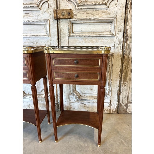 Pair of louis xvi style mahogany bedside tables, circa 1960. Two-drawer fronts with a shelf forming a stretcher. Carrara...