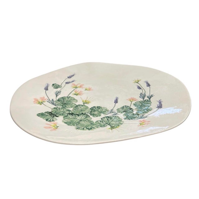 This handcrafted ceramic charger platter showcases a botanical motif brought to life with relief detailing. Set against a...