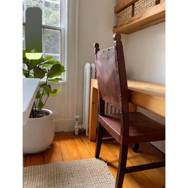 Set of 2 turn of the century leather and wood side chairs.
