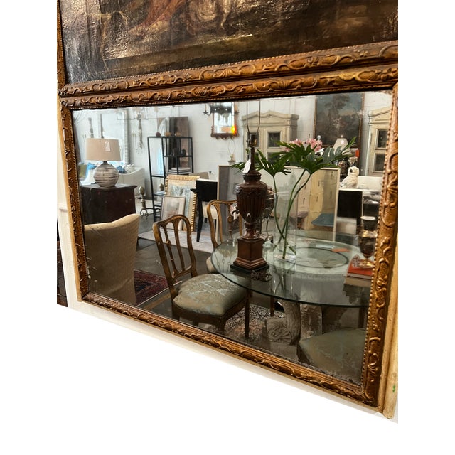 A French Louis XVI style trumeau mirror–the upper panel depicts a classical scene, likely influenced by French artists...