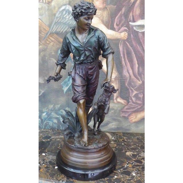 A substantial French bronze figural sculpture depicting a young boy accompanied by his dog, dating from circa 1920–1930...