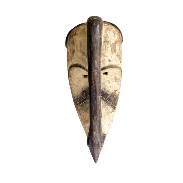 Superb vintage Fang Bird mask carved from a single piece of wood, featuring an elongated heart-shaped face rendered in...