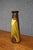 Weller Pottery vase featuring a tall, tapered form with a flared rim and glossy brown and golden ochre glaze. Decorated...