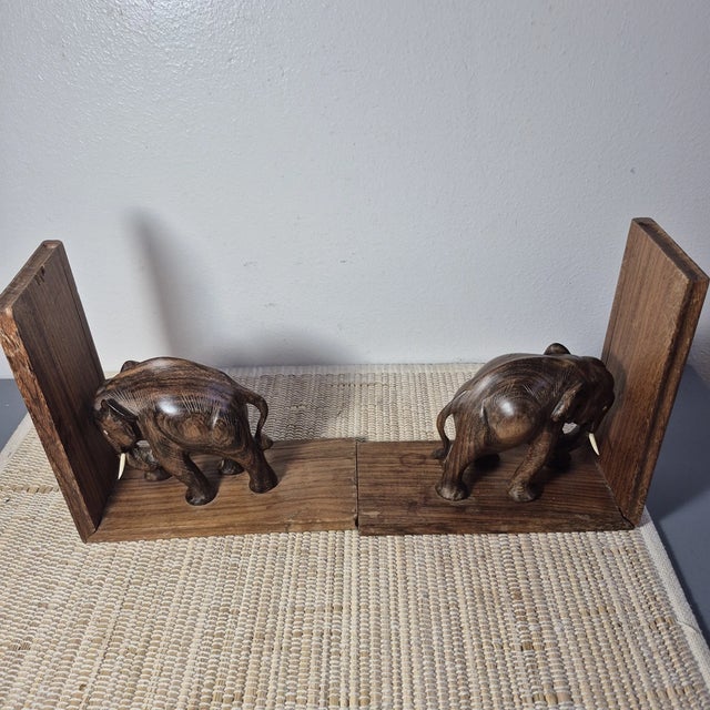 Add a touch of timeless charm to your bookshelf with this beautiful pair of vintage hand-carved wooden elephant bookends....